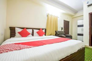 sypialnia z dużym łóżkiem z czerwonymi poduszkami w obiekcie OYO Flagship13162 Swiss Legrand w mieście Hajdarabad