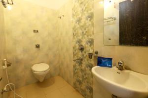 a bathroom with a toilet and a sink and a mirror at OYO Hotel Plaza Inn in Bhopal