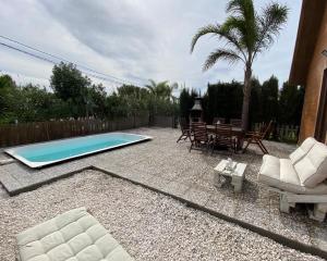 a backyard with a swimming pool and chairs and a table at Casas ROBRA in El Palmar