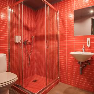 a red tiled bathroom with a shower and a sink at Boutique Apartment in Athens Center in Athens