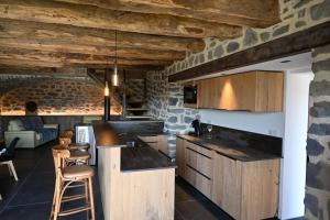 a kitchen with a counter and chairs in a room at Buron de Léon, en plein cœur de l Aubrac in Laguiole +59 photos