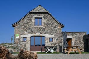 a stone building with a picnic table in front of it at Buron de Léon, en plein cœur de l Aubrac in Laguiole