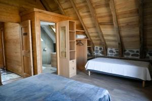 a bedroom with a bed in a room with wooden walls at Buron de Léon, en plein cœur de l Aubrac in Laguiole