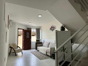 a living room with a couch and a staircase at Valentina Ramos Pousada - Joinville-SC in Joinville