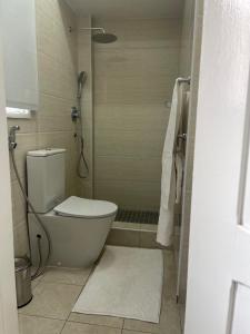 a small bathroom with a toilet and a shower at polana apartments in Maputo