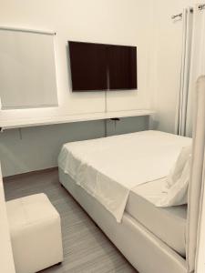 a hospital room with a bed and a flat screen tv at polana apartments in Maputo