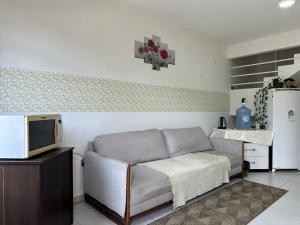 uma sala de estar com um sofá e uma televisão em Valentina Ramos Pousada - Joinville-SC em Joinville