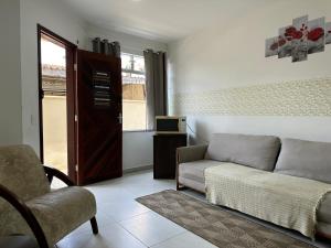 uma sala de estar com um sofá e uma cadeira em Valentina Ramos Pousada - Joinville-SC em Joinville