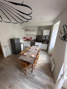 uma cozinha com mesa e cadeiras num quarto em lamaisondemamere em Tournon-sur-Rhône