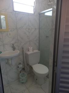 y baño con aseo y lavamanos. en Pousada da Mércia - Itapuã (BA), en Salvador