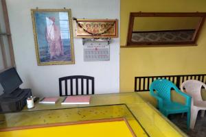 a room with a table and chairs and a picture at OYO Sathya Residency in Kulattūr