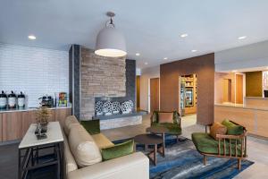 Fairfield Inn & Suites Kansas City Airport في كانساس سيتي: غرفة معيشة مع أريكة وكراسي