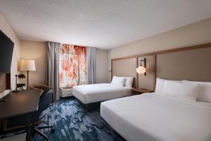 a hotel room with two beds and a desk at Fairfield Inn & Suites Kansas City Airport in Kansas City