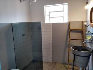 y baño con lavabo y ducha. en Casinha Original de Fazenda, en Araras