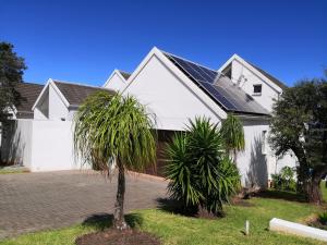 a white house with a palm tree in front of it at Ungabona in East London