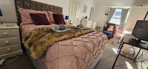 a bedroom with a large bed with a brown blanket at Scotts Lodge Newcastle County Down in Newcastle