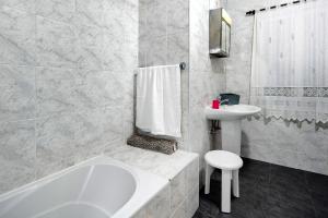 a bathroom with a tub and a toilet and a sink at Casa das Hortênsias in Raminho +25 photos