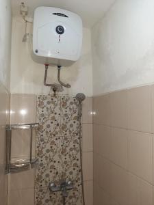een badkamer met een douche en een camera aan de muur bij Inapin Aja by Dio Property in Bandung