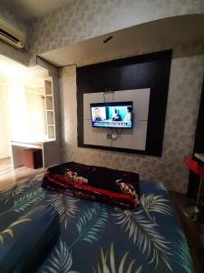 a bedroom with a bed and a flat screen tv at Inapin Aja by Dio Property in Bandung