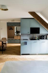 uma cozinha com armários brancos e uma sala de jantar em Bob W Peterhof em Freising