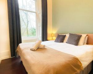 una camera da letto con un grande letto e una finestra di Catcune Suite - Four Bedroom Split Level Apartment a Gorebridge