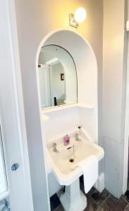 a bathroom with a sink and a mirror at Catcune Suite - Four Bedroom Split Level Apartment in Gorebridge