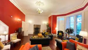 a living room with red walls and couches at Catcune Suite - Four Bedroom Split Level Apartment in Gorebridge