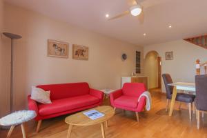 una sala de estar con 2 sillas rojas y una mesa. en 022 - Las Palmeras III - 001 - comfortHOLIDAYS, en Santa Pola