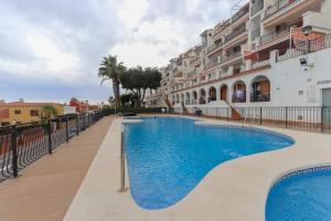 a swimming pool in front of a building at 022 - Las Palmeras III - 001 - comfortHOLIDAYS in Santa Pola