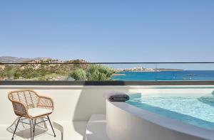a wicker chair sitting next to a swimming pool at The Sand Villa in Agios Nikolaos
