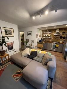 ein Wohnzimmer mit einem Sofa und einer Küche in der Unterkunft Rustic Modern 1BD Flat wGarden Stoke Newington! in London