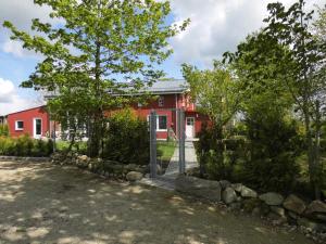 a red house with a fence in front of it at Ferienwohnung Offenbütteler Moor in Osterrade