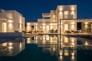 a villa with a swimming pool at night at Beautiful Paros Villa 1 Bedroom Villa Aura Beautiful Interior & Great For Couples Naousa in Livadia