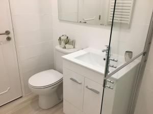 ein weißes Bad mit einem WC und einem Waschbecken in der Unterkunft Estoril 2 bedrooms by the Beach in Estoril