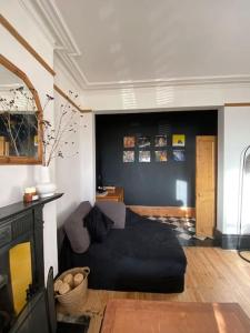 a living room with a couch and a tv at Edwardian Villa by the sea-side in Walton-on-the-Naze