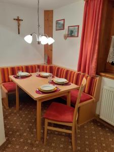 a table and chairs with plates and dishes on it at Haus Peintner in Tannheim