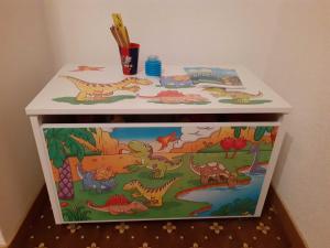 a toy chest with dinosaurs painted on it at Haus Peintner in Tannheim