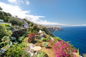 una vista de la costa amalfi con sillas y flores en A Paradise for your Soul en La Matanza de Acentejo
