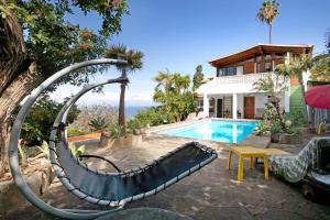 uma piscina com um escorrega junto a uma casa em A Paradise for your Soul em La Matanza de Acentejo