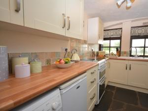a kitchen with a bowl of fruit on a wooden counter at 3 Bed in Okehampton TCOAH in Broadwoodwidger