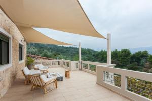 d'une terrasse avec des chaises et des tables sur un balcon. dans l'établissement Aoria Villa By Hope Estate, à Arménoi