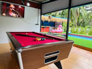 a billiard table in a room with a pool table at บ้านโกจุยรีสอร์ต in Ban Ratchaphruk