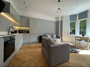a living room with a couch and a kitchen at Superior Stay, Sophia Gardens, City Centre and Stadium Sleeps 4 in Cardiff
