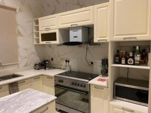 a kitchen with white cabinets and a stove top oven at Maestro in Lagos