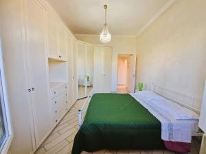 - une chambre avec un lit vert et des placards blancs dans l'établissement Testaccio appartamento per gli amanti di un caffè in terrazzo, à Rome