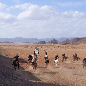a group of people riding horses in the desert at Wadi rum galaxy camp in Wadi Rum