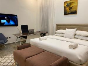 a hotel room with a bed and a desk with a laptop at Maestro in Lagos