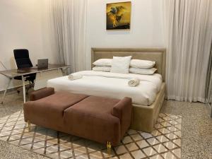 um quarto com uma cama, uma cadeira e uma secretária em Maestro em Lagos