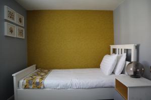 a bedroom with a bed with a yellow wall at Hardwick Arms Hotel in Sedgefield