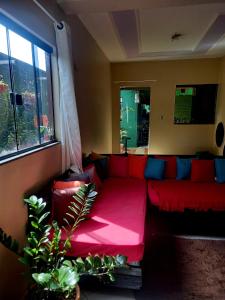 un sofá rojo en una sala de estar con ventana en Verdes Hostel Palmas-TO, en Palmas